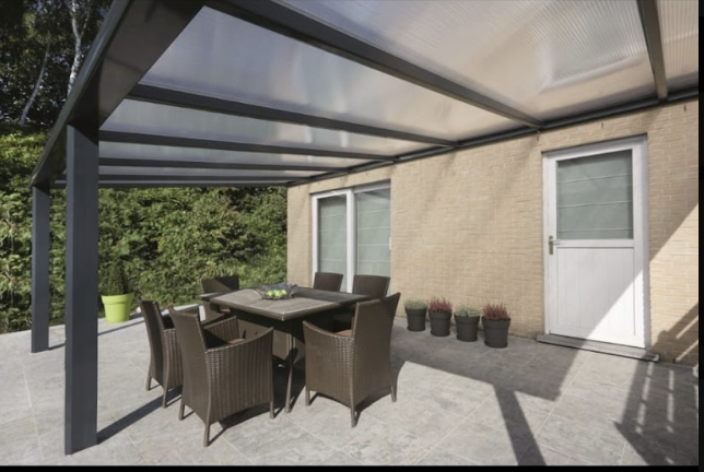 Antraciet aluminium overkapping met polycarbonaat dak boven een terrasset aan een Nederlandse woning