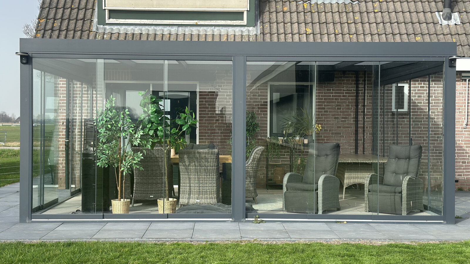 Volledige tuinkamer met glazen schuifwanden en aluminium frame in de tuin