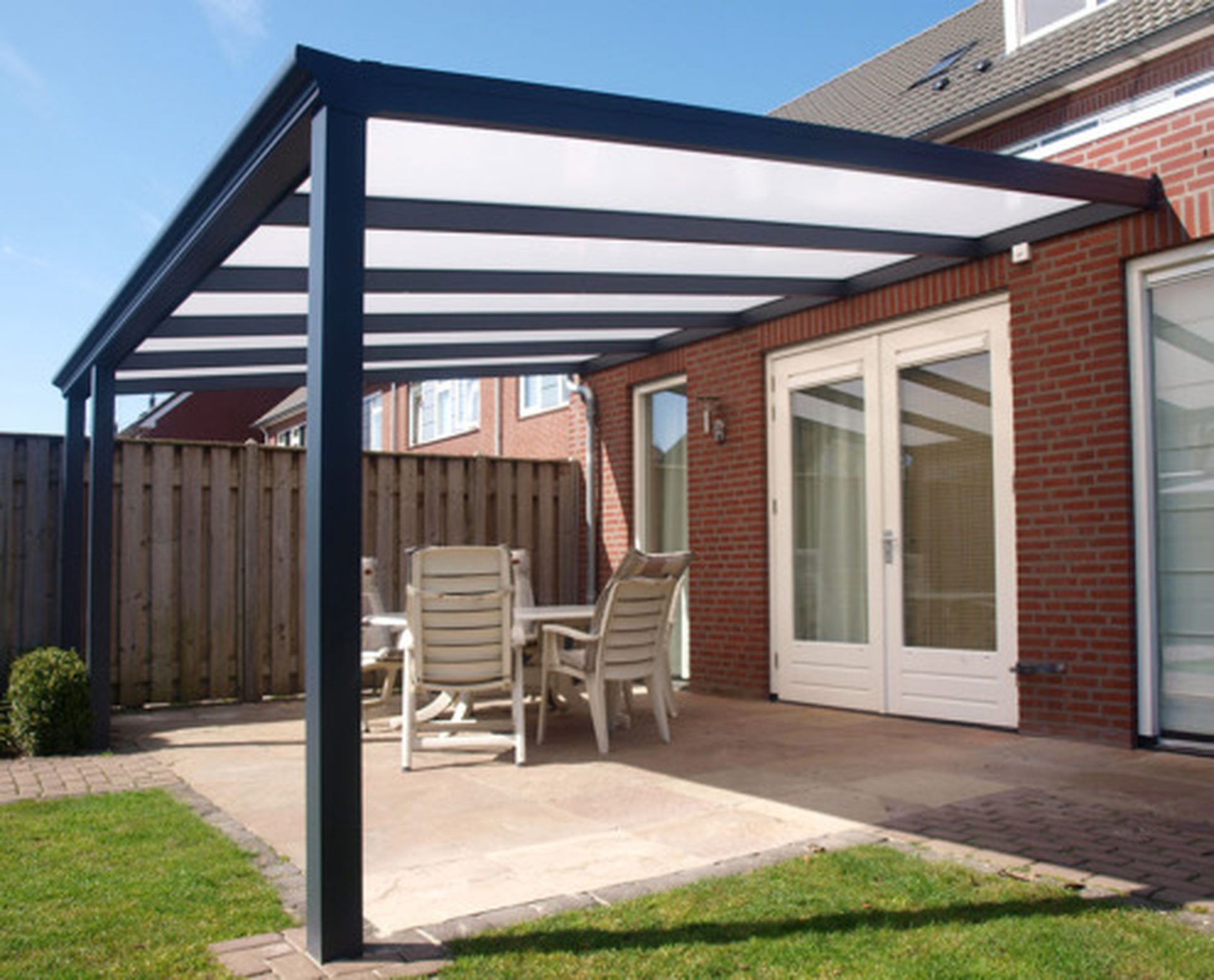 Antracietkleurige aluminium overkapping met polycarbonaat dak aan een woning